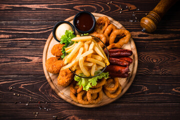 Sticker - Fried chicken legs, crispy onion rings, breaded squid rings, sausages, french fries, sauces and greens.