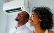 happy black young man and woman enjoying the coolness of the air conditioner in their home