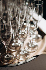 Wall Mural - Many empty champagne or wine glasses sparkle in the sun. Preparation for a reception or holiday, a container for alcoholic beverages. Restaurant, catering, service