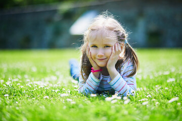 Wall Mural - Happy cheerful preschool girl walking in park