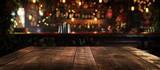 Fototapeta Pokój dzieciecy - An empty wooden table is set in front of a bar at a restaurant. The background features bokeh lights, creating a warm and inviting atmosphere.