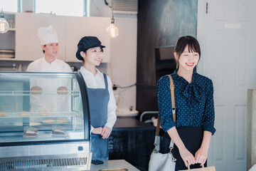 Poster - こだわりのお店でテイクアウトをする若い女性