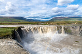 Fototapeta Tęcza - Panoramic view from the Eastern bank of the Godafoss waterfall in Iceland which runs through the Bardardalur valley: light rainbow visible