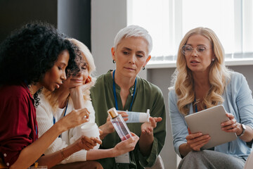 Poster - Group of confident mature women examining beauty products during specialized conference