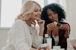 © gstockstudio - Three mature women discussing beauty treatments while sitting at the desk together