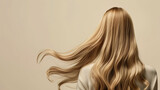 Fototapeta  - Blonde girl with long wavy hair on a white background.