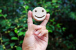 Peace hands holding wooden happy faces, International Day of Happiness concept, customer reviews, emotional intelligence, emotional control balance, feedback ratings, mental health.