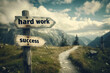 © Madeleine Steinbach - Arrow signs saying Hard work and Success pointing to a path in the mountains