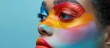 A womans face is adorned with vibrant and bright colors, resembling the makeup style often seen on drag queens.