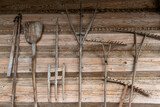 Fototapeta  - Drewniane narzędzia rolnicze na tle ściany wiejskiej drewnianej chaty