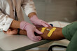 © Seventyfour - Close up unrecognizable nurse preparing patient for IV drip treatment and putting bandages on arm copy space