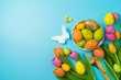 Easter holiday table setting with easter eggs and tulip flowers on blue background. Top view, flat lay composition