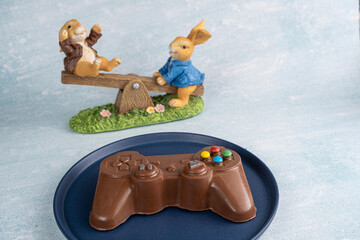 Wall Mural - Milk chocolate in the shape of a video game controller alongside small rabbits_1.