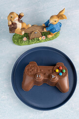 Wall Mural - Milk chocolate in the shape of a video game controller alongside small rabbits_3.