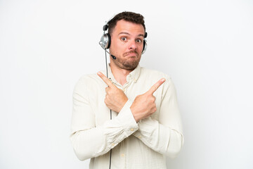 Wall Mural - Telemarketer caucasian man working with a headset isolated on white background pointing to the laterals having doubts