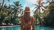 © Artistic Visions - Woman Relaxing by a Tropical Poolside in Exotic Vacation Location