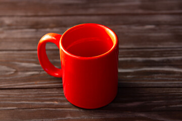 Red blank mug close-up on brown wooden background