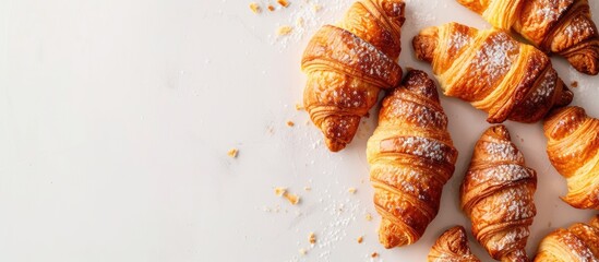 Poster - Delicious homemade croissants are shown on a white background, topped with a dusting of powdered sugar for a sweet finish.