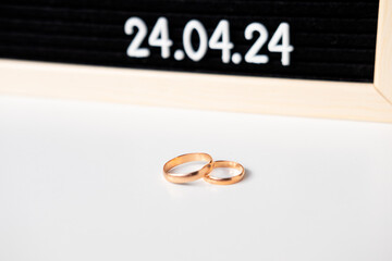 Rings of the newlyweds on the background of a Beautiful date for the wedding 04.24.2024 on a black lettobord