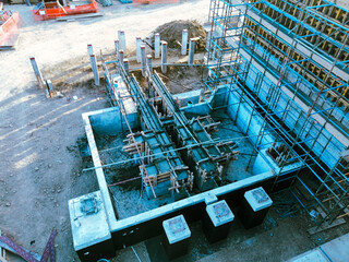 A construction site with scaffolding and a blue sky in the background. The construction site is in the process of building a structure