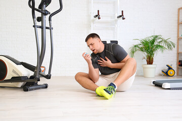 Sticker - Sporty young man using inhaler in gym