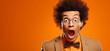 Portrait d'un homme noir surpris, jeune homme sur un fond orange, image avec espace pour texte.