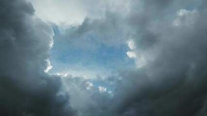 Wall Mural - Dark storm clouds moving and the hole with a piece of blue sky, timelapse 4k