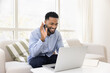 © fizkes - Happy African American student guy enjoying online conversation at laptop, waving hand hello, smiling, laughing, using Internet technology connection for education, teaching, communication on Internet