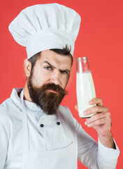 Dairy products and cooking. Chef recommendation. Restaurant dairy meal, homemade kitchen. Serious chef man in white uniform with bottle of milkshake or yogurt. Bearded male cook with bottle of milk.