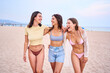 © CarlosBarquero - Group of Happy caucasian girl friends in bikini enjoying vacation at the beach outdoors. Walking in the sand and laughing a lot by the sea in a sunny day with swimwear celebrating carefree