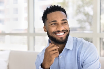 Wall Mural - Happy handsome young African American business man looking away, showing healthy white teeth, touching chin. Successful manager, professional, businessman, entrepreneur casual portrait
