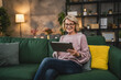 © Miljan Živković - mature blonde woman with eyeglasses use digital tablet at home