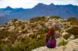© Jakub - back view of hiker girl sitting at the top of mount maroon and admiring the panorama of famous mount barney; resting at the summit of the mountain in south east queensland, australia