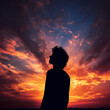 Silhouette of a person against a sunset sky. 