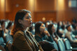 a female entrepreneur asking a question while attending business seminar in conference hall