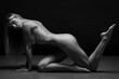 Abstract fine-art portrait. Black and white photo of nude beautiful woman. Female body on black background.	