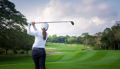 Wall Mural - Professional woman golfer teeing golf in golf tournament competition at golf course for winner