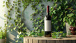 Red wine bottle with a blank label on a wooden table, surrounded by lush green leaves.