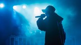 Silhouette of rap singer performing on stage. Bright blue background with hip hop artist performing on concert in night club