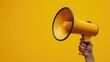 A hand holding a yellow megaphone against a bright yellow background. Perfect for advertising or communication concepts