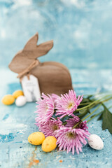 Poster - Pink flowers and yellow and white colored easter eggs, and easter bunny on a blue picturesque oil painting background close up. Spring Mockups.Layout. Easter pastel background