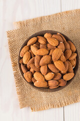 Wall Mural - Raw peeled almonds in brown bowl
