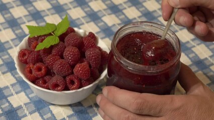 Wall Mural - raspberry jam, scoop jam from a jar with a spoon