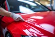 © Yuliia - Professional unrecognizable Caucasian specialist male man guy worker master wrapping installing protective film vinyl foil new red sport car automobile transport paint protection indoors salon service