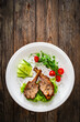 Lamb chops with bone and fresh vegetables on wooden table