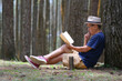 © Simon - Man enjoying his leisure time sitting under a tree in the park, reading a book
