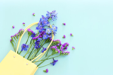 Wall Mural - Top view image of violet delphinium flowers composition over blue background