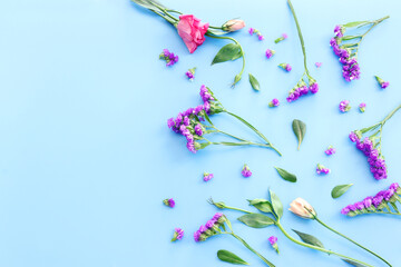 Wall Mural - Top view image of pink flowers composition over pastel blue background .Flat lay