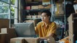 © buraratn - SME entrepreneur Small business entrepreneurs Online selling ideas,Happy Young Asian business owner work on computer and a boxs at home,delivery SME procurement package box deliver to customers,