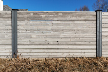 
Wooden board fence with a stone and metal post in the middle